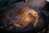 Golden roast chicken with herbs on the Big Green Egg Rotisserie, ideal for flavorful cooking in Northern Ireland and Ireland.