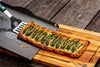 Solidteknics baking tray with a freshly baked asparagus tart being served on a wooden board, available at Stove Yard Cheshire.