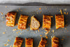 Close-up of golden sausage rolls on a Solidteknics baking tray, highlighting even baking results. Available at Stove Yard Cheshire.