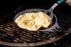 Solidteknics Iron Crêpe Pan grilling crepes on a Big Green Egg, highlighting its even heat distribution and versatile cooking capabilities.