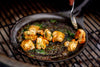 Solidteknics Iron Crêpe Pan used for searing scallops with fresh herbs on a Big Green Egg grill.